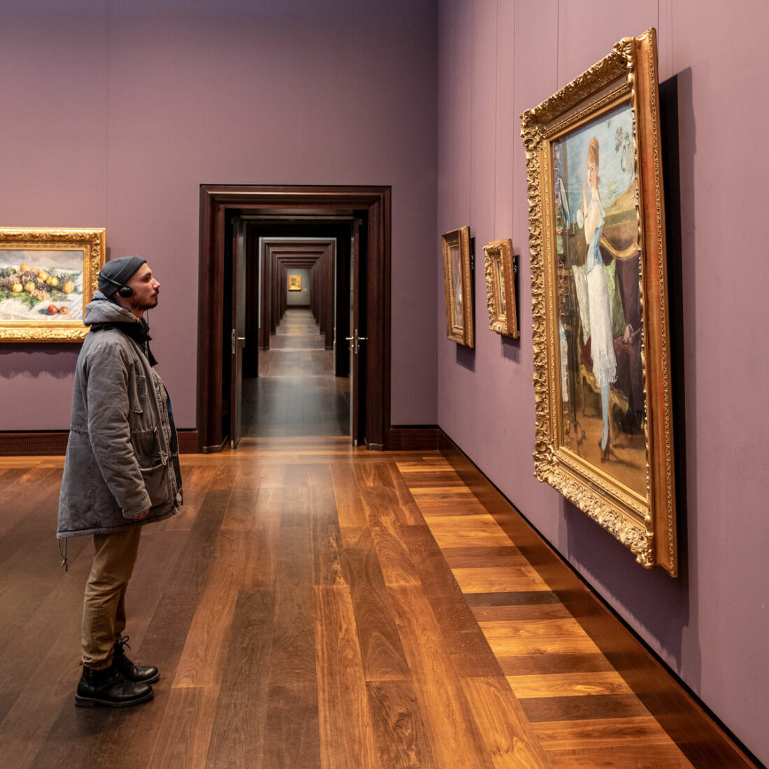 Ein Besucher der Kunsthalle steht fasziniert vor einem ausgestellten Gemälde und verfällt in Träume.