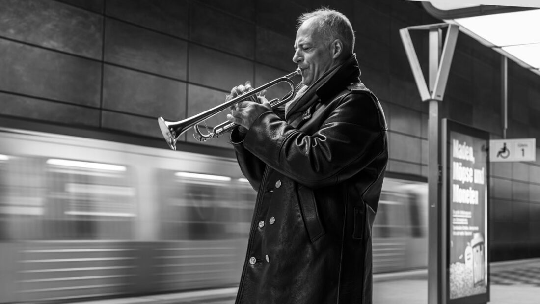 Ein Freund spielt auf seiner Trompete und begrüßt so eine einfahrende U-Bahn