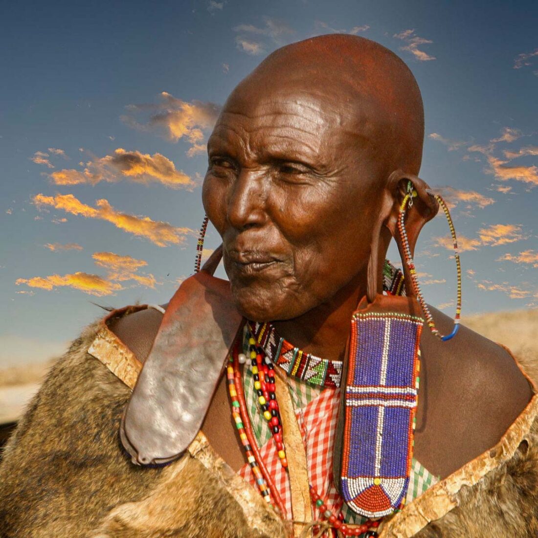 Portrait einer Masai-Frau mit abgewandten Blick und traditioneller Masai-Bekleidung in der Masai Mara